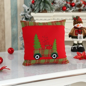 Detail of red velvet Christmas cushion cover with embroidered vintage truck and tree