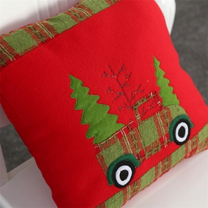Close-up of embroidered velvet Christmas pillow cover featuring a green holiday truck motif