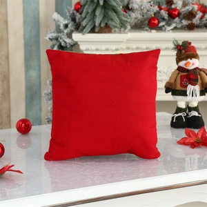 Detail of red velvet Christmas cushion cover on marble table with festive decorations
