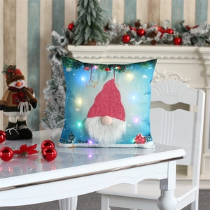 Close-up of LED light-up Christmas gnome pillowcase on a festive white table setting