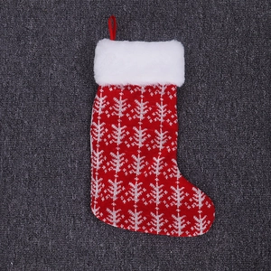 Detail of red and white knitted Christmas stocking with faux fur cuff and snowflake pattern