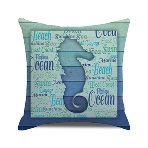 Detail of square cushion cover with seahorse print and beach text on wood texture