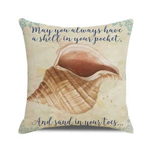 Detail of linen cushion cover showing watercolor conch design and coastal text