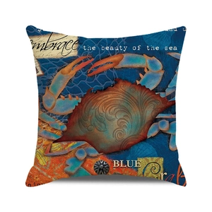 Detail of square nautical pillowcase featuring a vintage crab print and blue sea motif