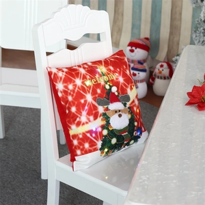 Detail of Christmas pillow cover featuring LED lights and a reindeer on a white chair
