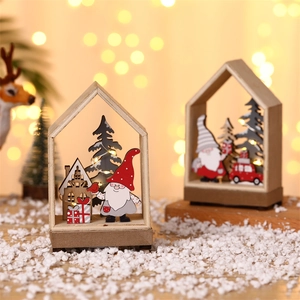 Close-up of lighted Christmas wooden gnome house with LED warm glow and snowy trees