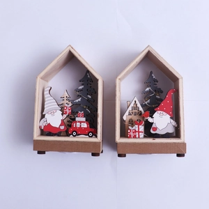 Detail view of two wooden Christmas house ornaments with Santa and miniature trees