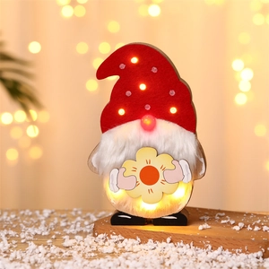 Close-up of a festive wooden gnome with warm LED light and yellow sunflower detail