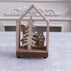 Detailed view of a wooden Christmas cabin ornament with interior trees and micro LED lights