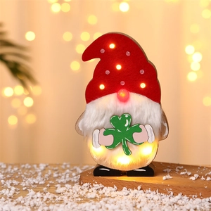Detail of a lighted wood gnome with green clover and LED nose for festive holiday decor