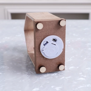 Detail of wooden Christmas house base with LED battery compartment and ON/OFF switch