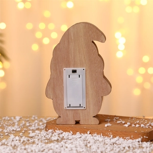 Detail of wooden gnome ornament back featuring a white battery box and toggle power switch