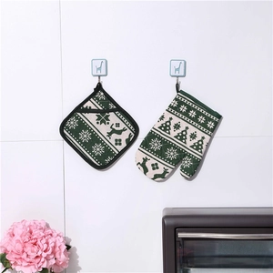 Detailed view of dark green Christmas oven mitt and pot holder set with reindeer pattern
