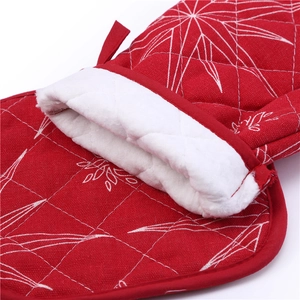 Detail of red Christmas oven mitt and pot holder showing quilted snowflake fabric pattern