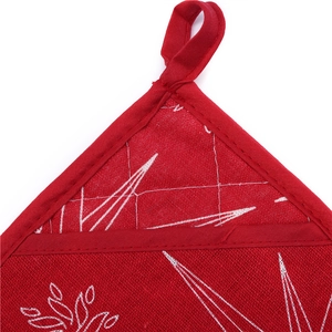 Detailed close-up of red Christmas oven mitt hanging loop and durable quilted fabric
