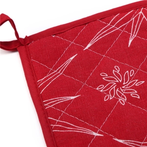Close-up of red Christmas oven mitt detail with white quilted pattern and hanging loop