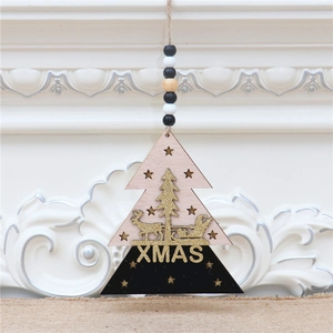 Close-up of a 3D wooden Christmas tree ornament with golden glitter reindeer and XMAS text
