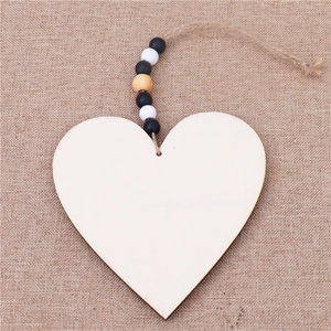 Detail of wooden heart ornament with decorative beads and twine on rustic burlap background