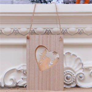 Détail d'un pendentif de Noël en bois avec cœur découpé et scène d'hiver artisanale