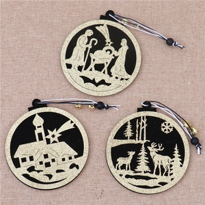 Detalle de tres adornos navideños circulares de madera en negro y dorado con yute