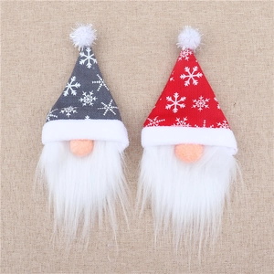 Close-up of red and grey Christmas gnome wine bottle covers with snowflake patterns