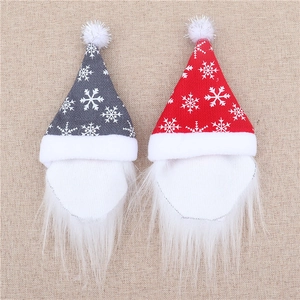 Close-up of red and grey Christmas gnome bottle covers with snowflake prints and fur