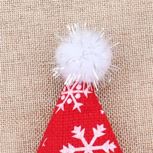 Macro detail of red knitted Christmas bottle cap with white snowflakes and plush pompom