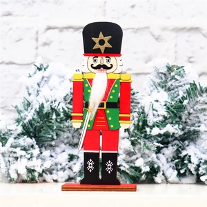 Classic wooden nutcracker soldier on red base with snowy pine branch background