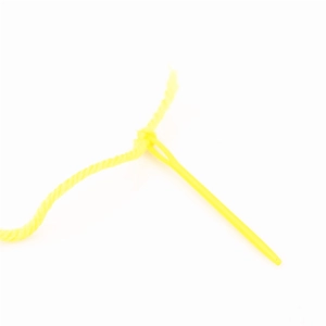 Macro di un ago di sicurezza in plastica gialla con filato per lavoretti manuali per bambini