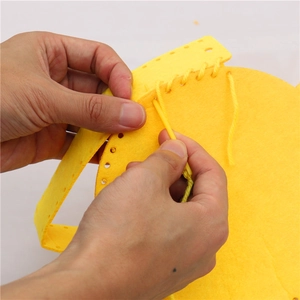 Dettaglio del kit borsa in feltro fai-da-te con tessuto giallo, ago in plastica e filo