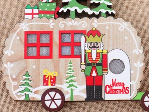 Detail of wooden RV-shaped Christmas ornament with colorful Nutcracker print and greetings