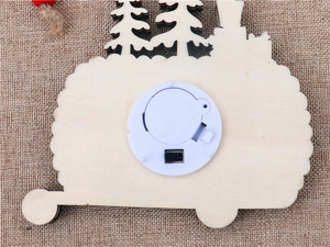 Close-up of the wooden ornament back showing LED battery compartment and switch