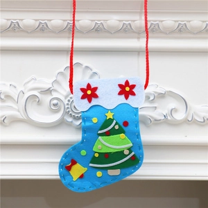 Detail of DIY Christmas stocking craft with blue felt, white tree patterns and red rope