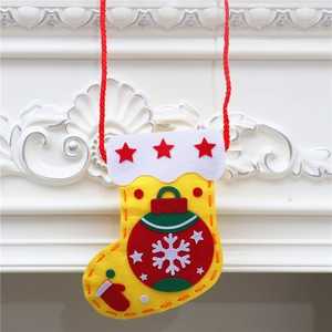 Close-up of yellow felt DIY Christmas stocking with red star and snowflake details