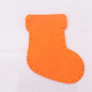 Macro detail of DIY orange felt Christmas stocking with decorative yellow stitching