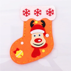 Detail of DIY Christmas stocking craft with orange felt fabric and reindeer motif decor