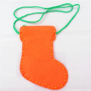 Detail of orange felt DIY Christmas stocking bag with yellow stitching and green handle