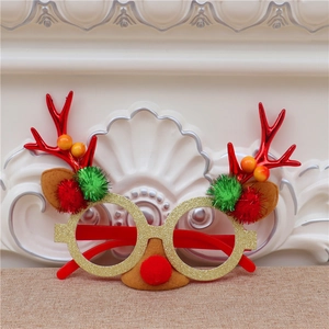 Détail de lunettes de Noël avec bois de renne, pompons verts et monture dorée pailletée