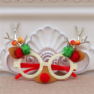 Détail de lunettes de Noël festives avec monture dorée pailletée et bois de renne en feutre