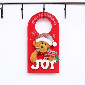Detail of red felt Christmas door hanger with plush bear and white wooden JOY letters