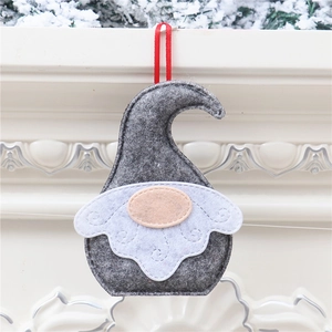 Detail of grey Christmas gnome ornament with white beard and red ribbon on a fireplace