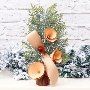 Detailed close-up of 25cm mini Christmas tree with champagne ribbon and wooden base
