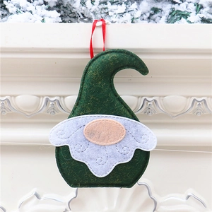 Detail of green gnome ornament with white beard hanging on a white fireplace decor