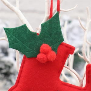 Close-up of handmade red felt Christmas stocking with green holly leaves and red berry pompoms