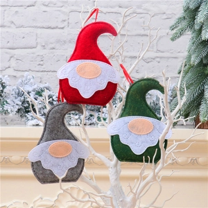 Close-up of red, green, and gray Christmas gnome felt ornaments with hanging ropes