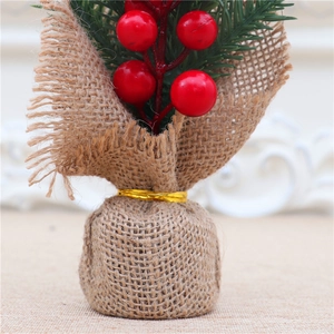 Macro detail of 25cm mini Christmas tree with red berries, pine needles and burlap base