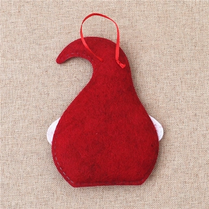 Close-up of red felt Santa ornament with fine stitching and ribbon on burlap
