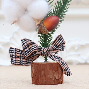 Close-up of 25cm mini Christmas tree with cotton flowers, pine cones and plaid bow