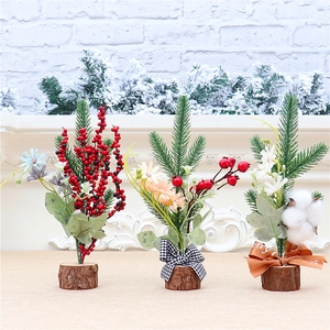 Detailed view of three mini desktop Christmas trees with red berries and wooden bases