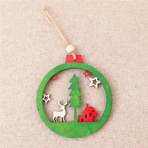 Detail of wooden Christmas ornament with hollow carved reindeer, tree and red house motifs